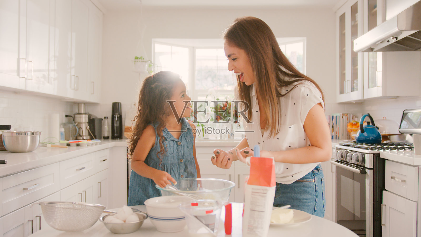妈妈和女儿在家里的厨房里一起烘焙玩耍照片摄影图片