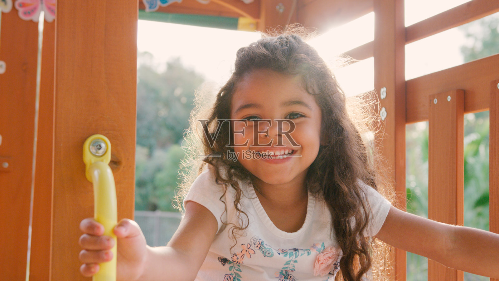 一个年轻女孩在游乐场设备上玩耍时，面带微笑的肖像照片摄影图片
