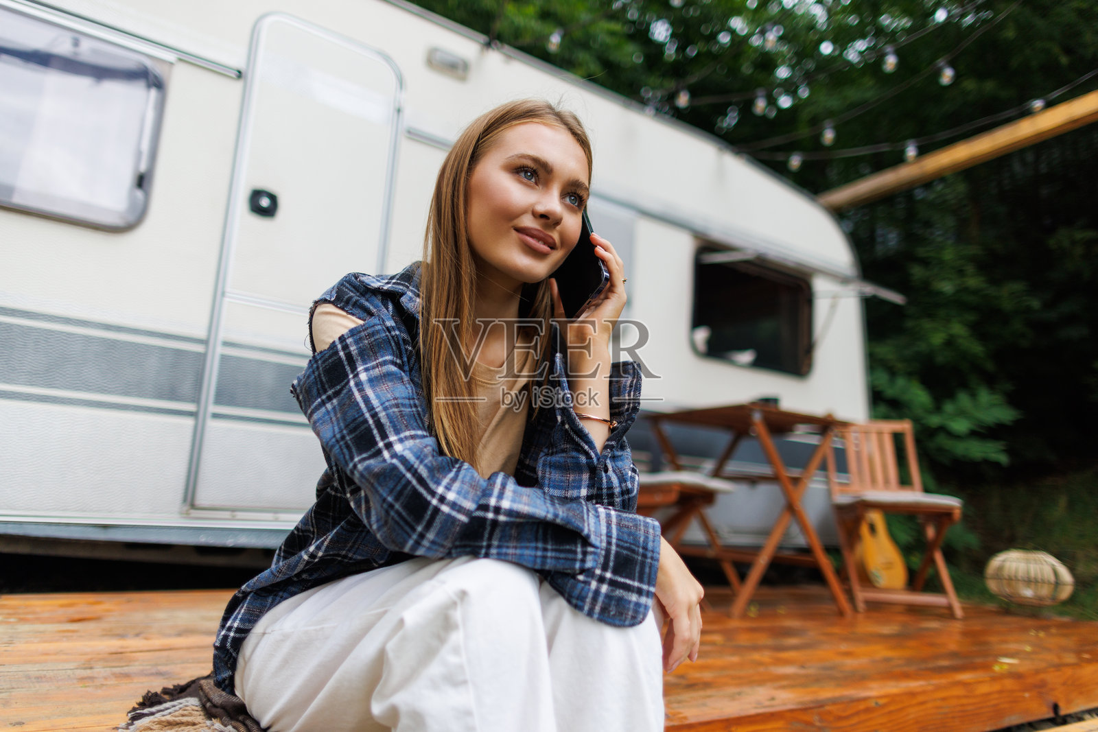 年轻女子坐在露营车里打电话照片摄影图片