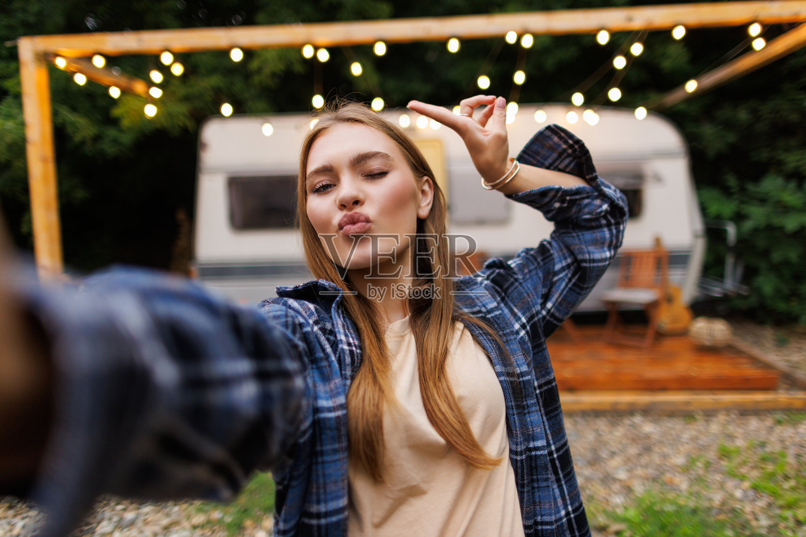 年轻女子坐在野营车旁的桌子旁自拍照片摄影图片