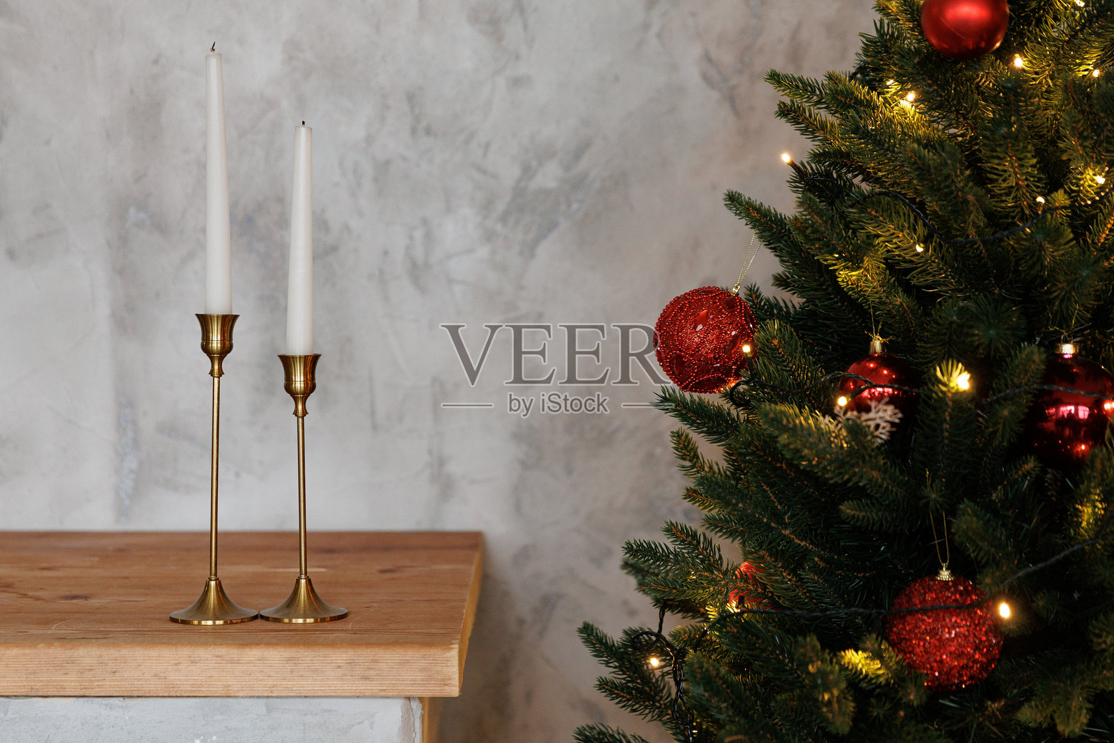 圣诞树，上面挂着红色的装饰品，桌上放着蜡烛照片摄影图片