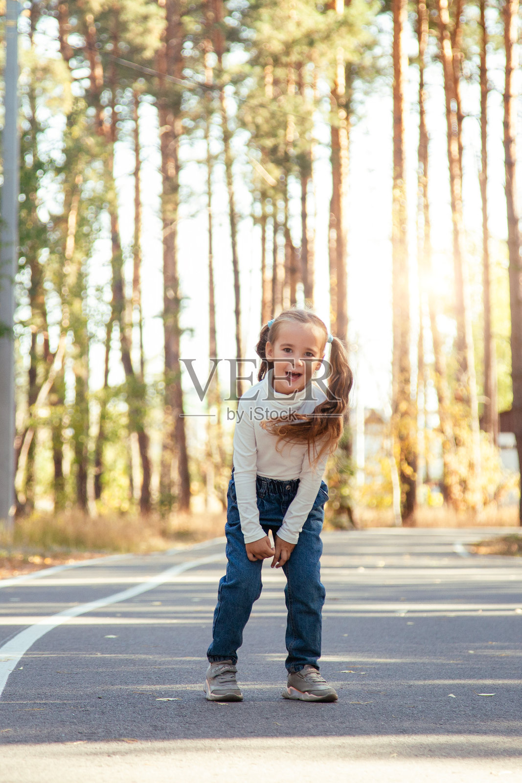日落时分，小学女生在公园里散步照片摄影图片