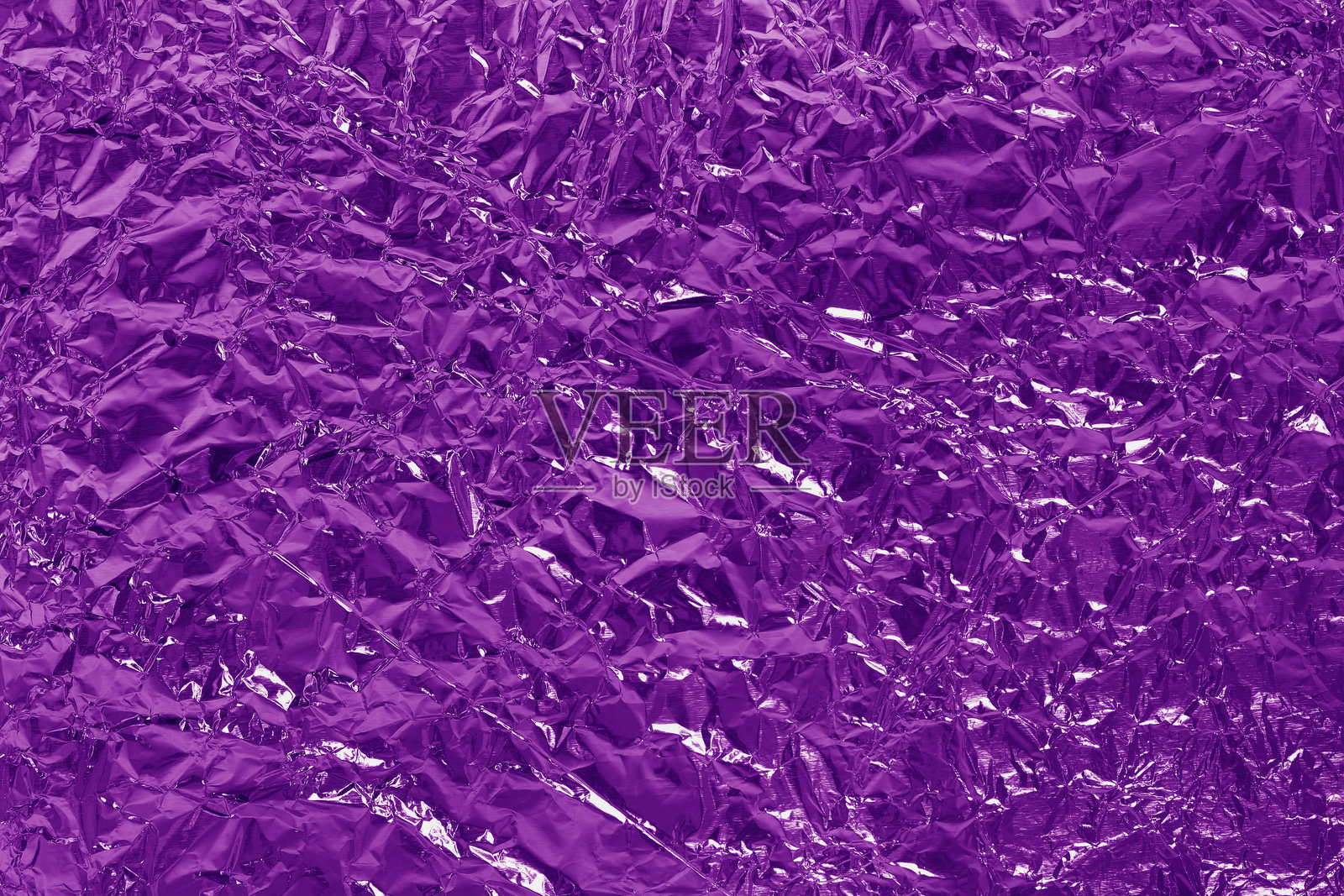 闪亮的紫色箔纹理背景，带有褶皱和波浪的紫罗兰包装纸图案。照片摄影图片