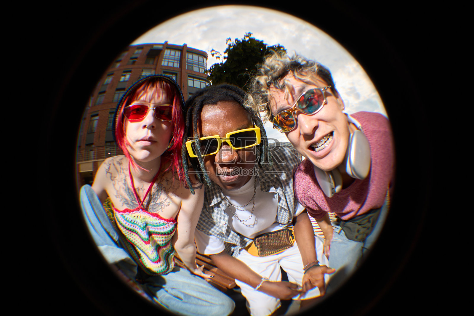 戴着太阳镜、看向鱼眼相机的多元化年轻人的肖像照片摄影图片