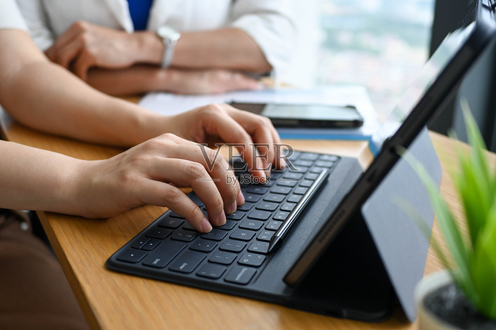 专注的亚洲女商人坐在办公桌前用电脑打字照片摄影图片