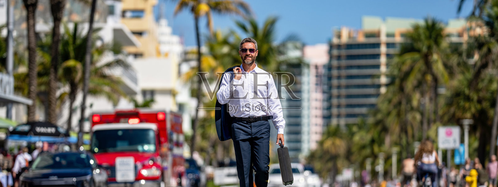 西装革履的富商。商务肖像。成功的商人带着公文包在户外行走。商人拿着公文包。成功交易后的商人。企业商务。大城市照片摄影图片