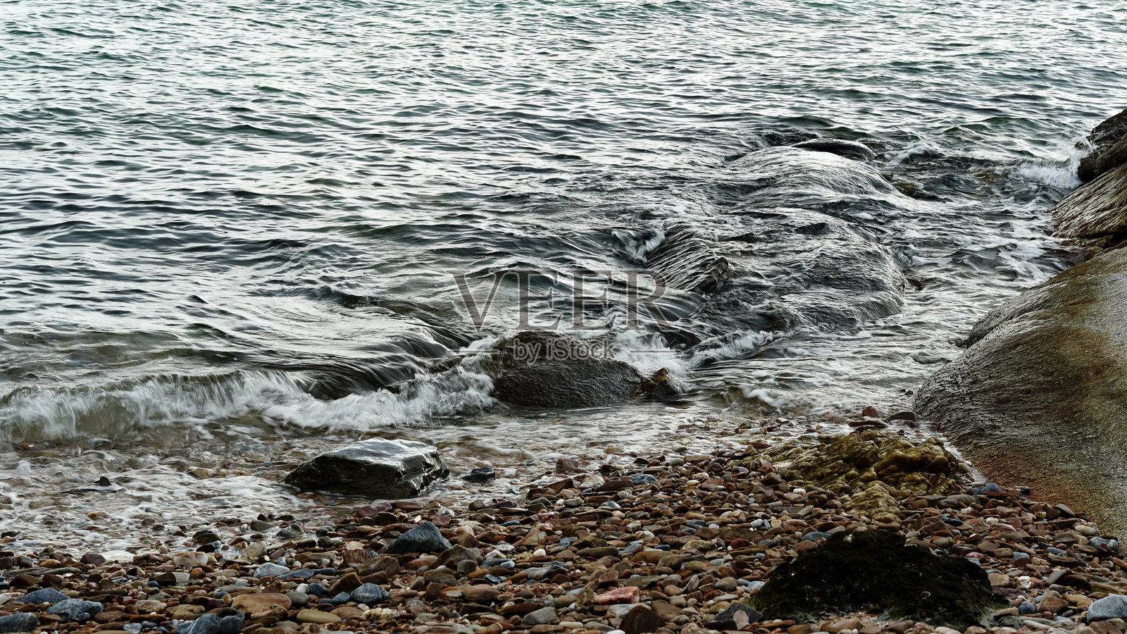 海浪拍打着海岸的岩石。照片摄影图片