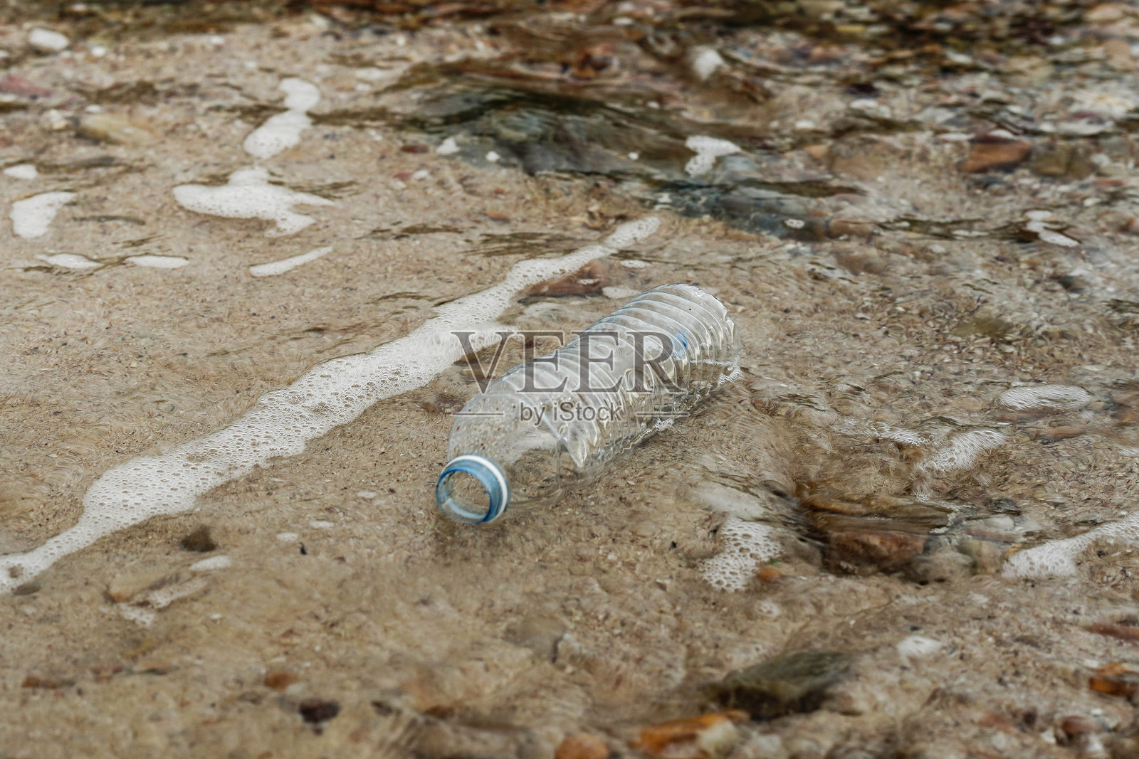 沙滩上的塑料瓶污染照片摄影图片