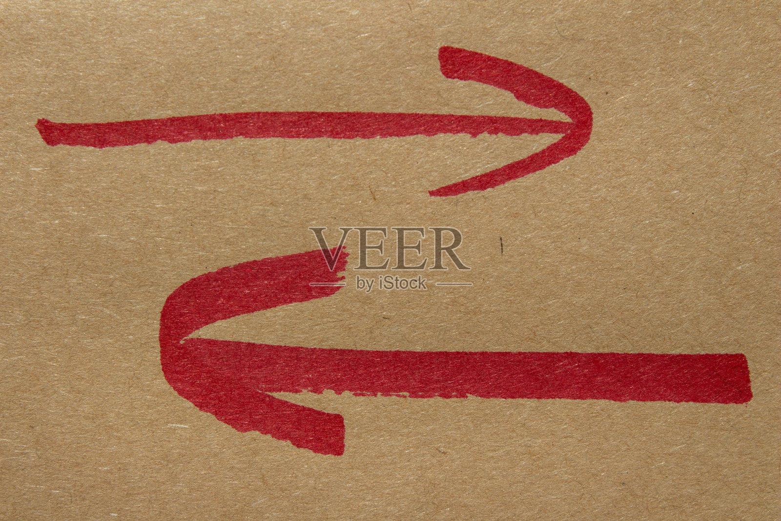 红色的手绘箭头，背景为棕色照片摄影图片