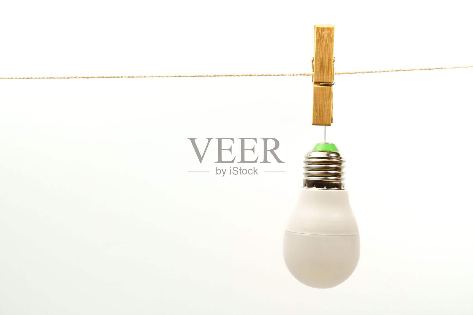 灯泡挂在绳子上，用晾衣夹固定照片摄影图片