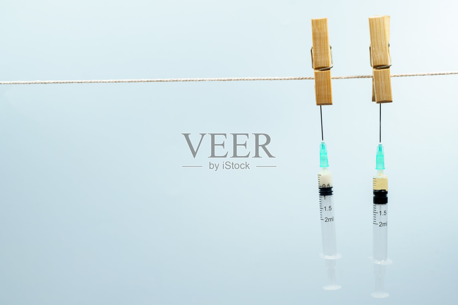 挂在绳子上的注射器，药物研发概念照片摄影图片