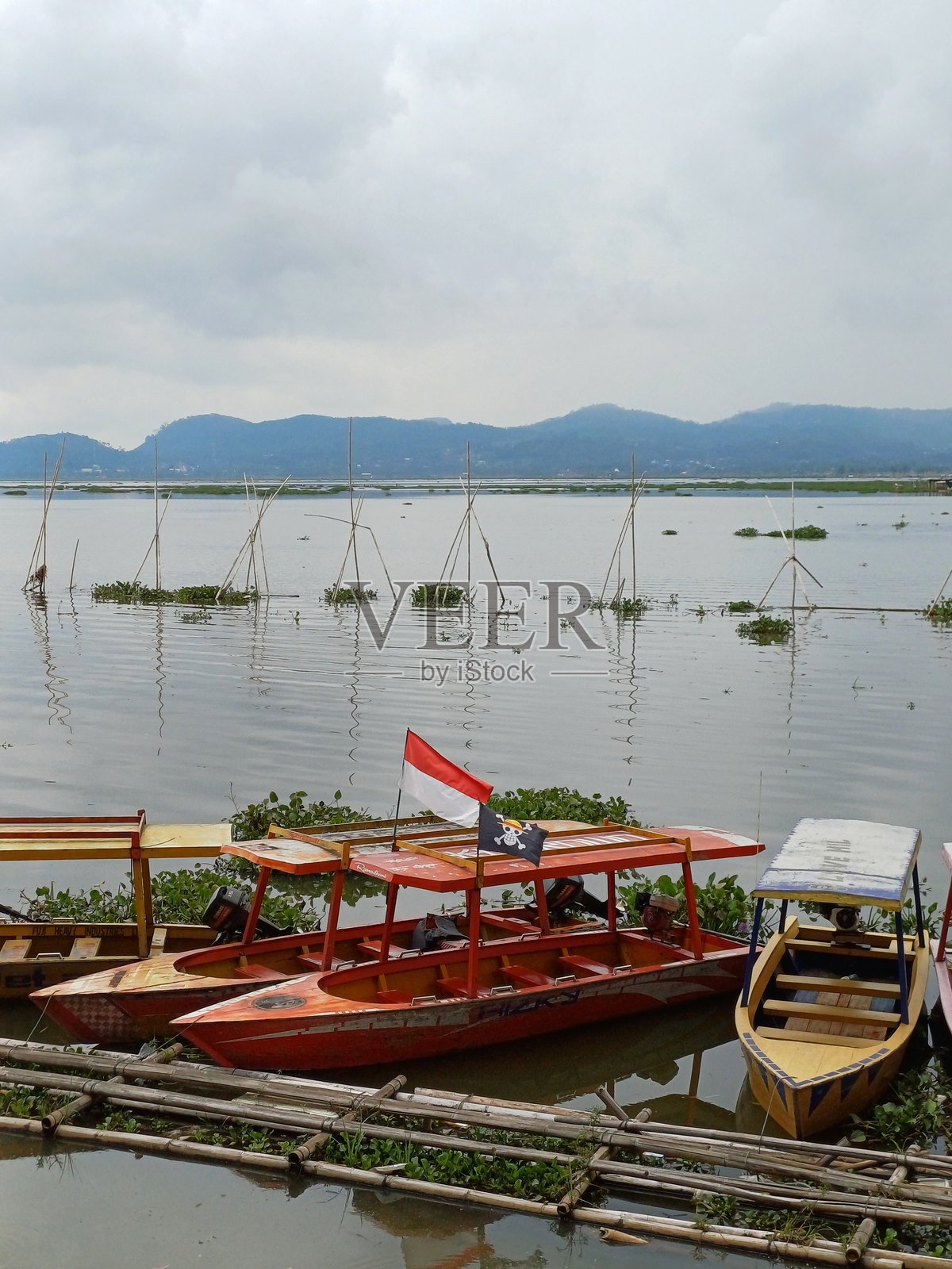 宁静的湖泊，远眺群山与船只照片摄影图片