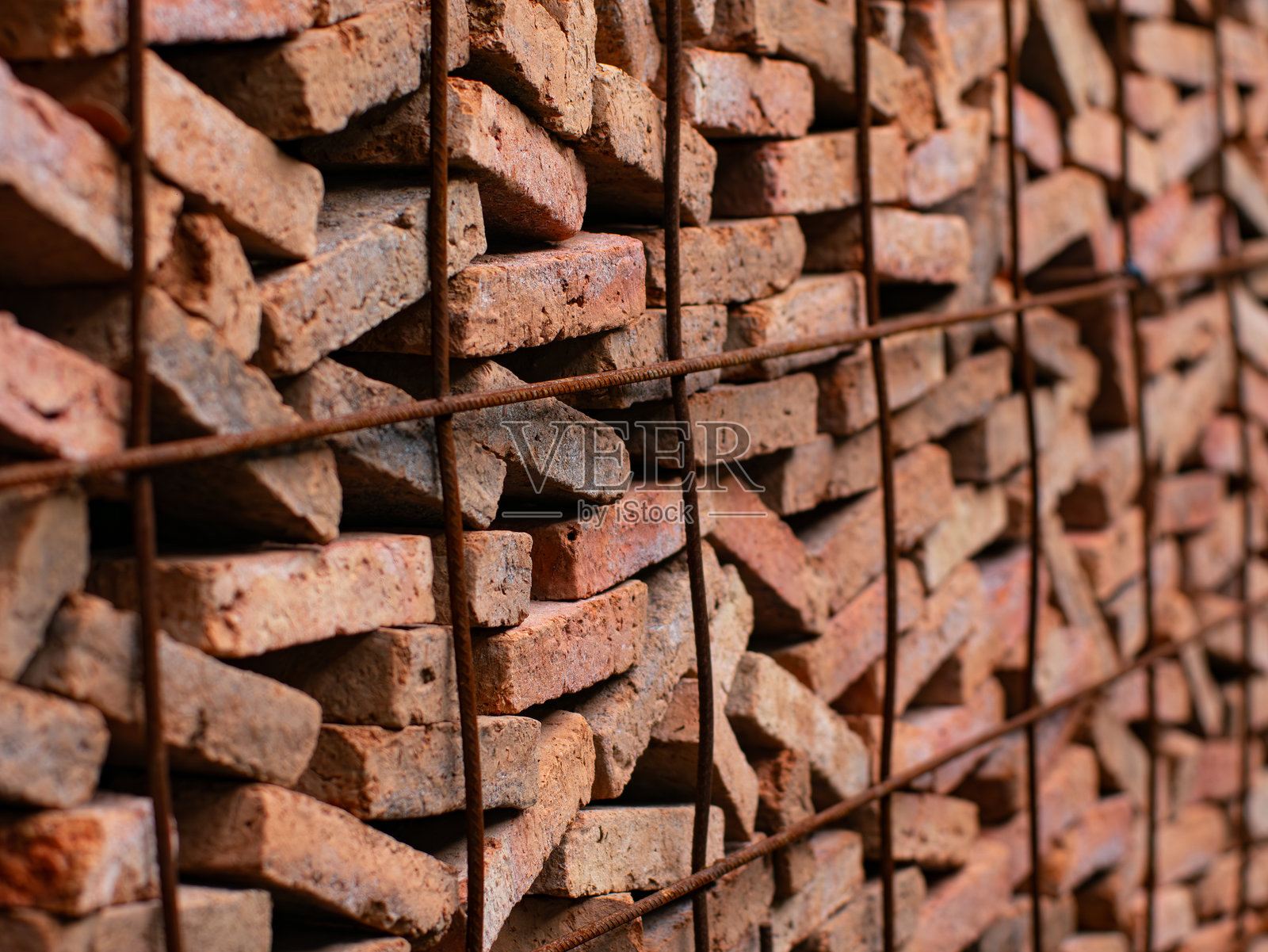 建筑工地上的叠放红砖——为建筑项目整齐堆放的传统建筑材料，储存在排列的货架上。照片摄影图片