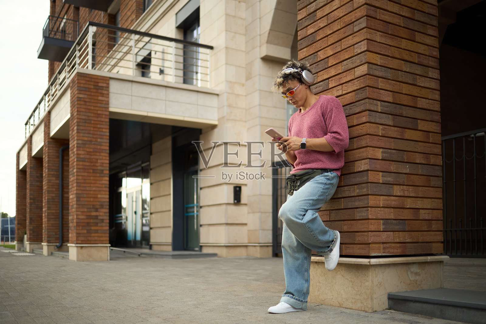 年轻高加索男性在户外听音乐并使用智能手机照片摄影图片