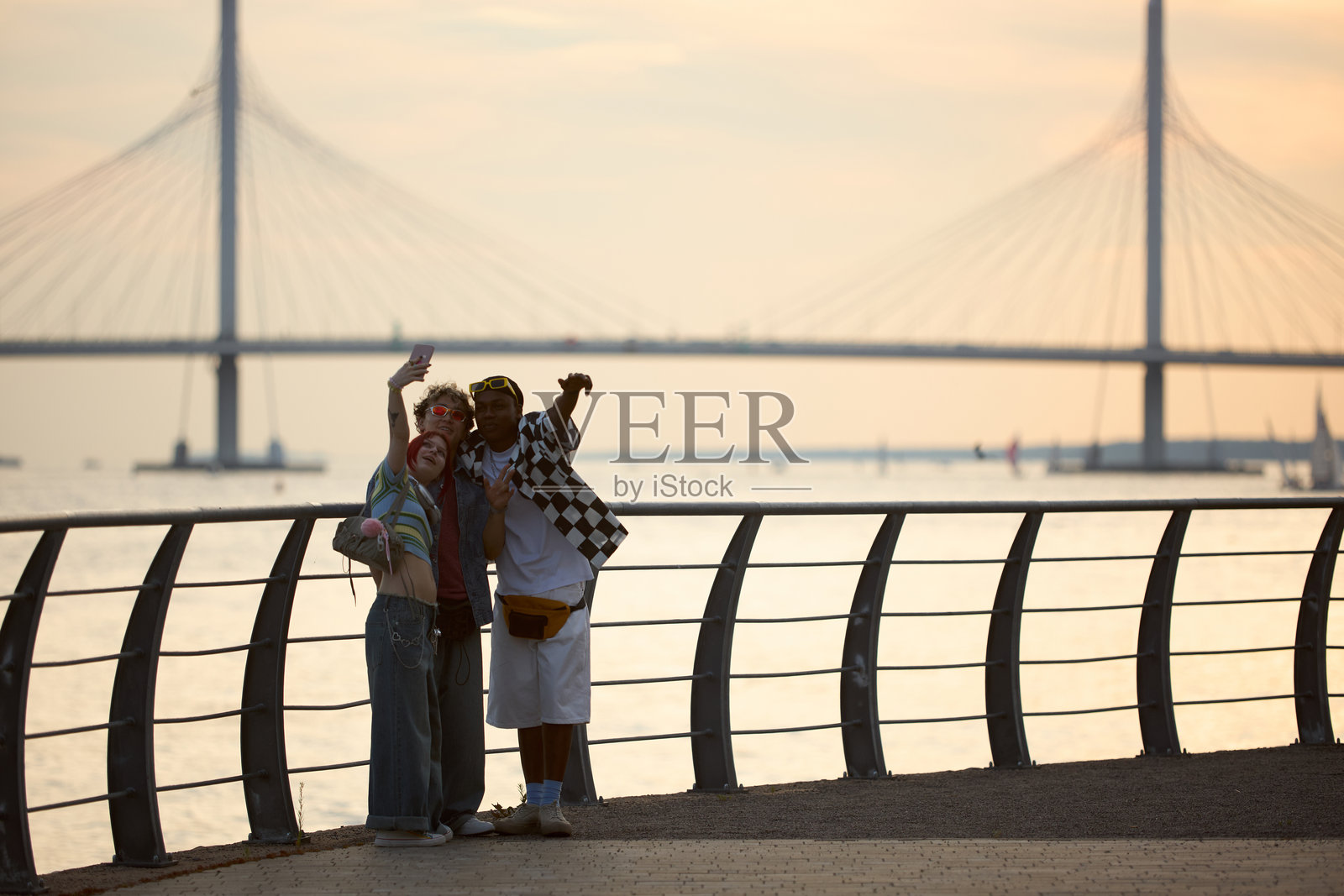 一群多元化的青少年在滨水桥附近一起自拍照片摄影图片