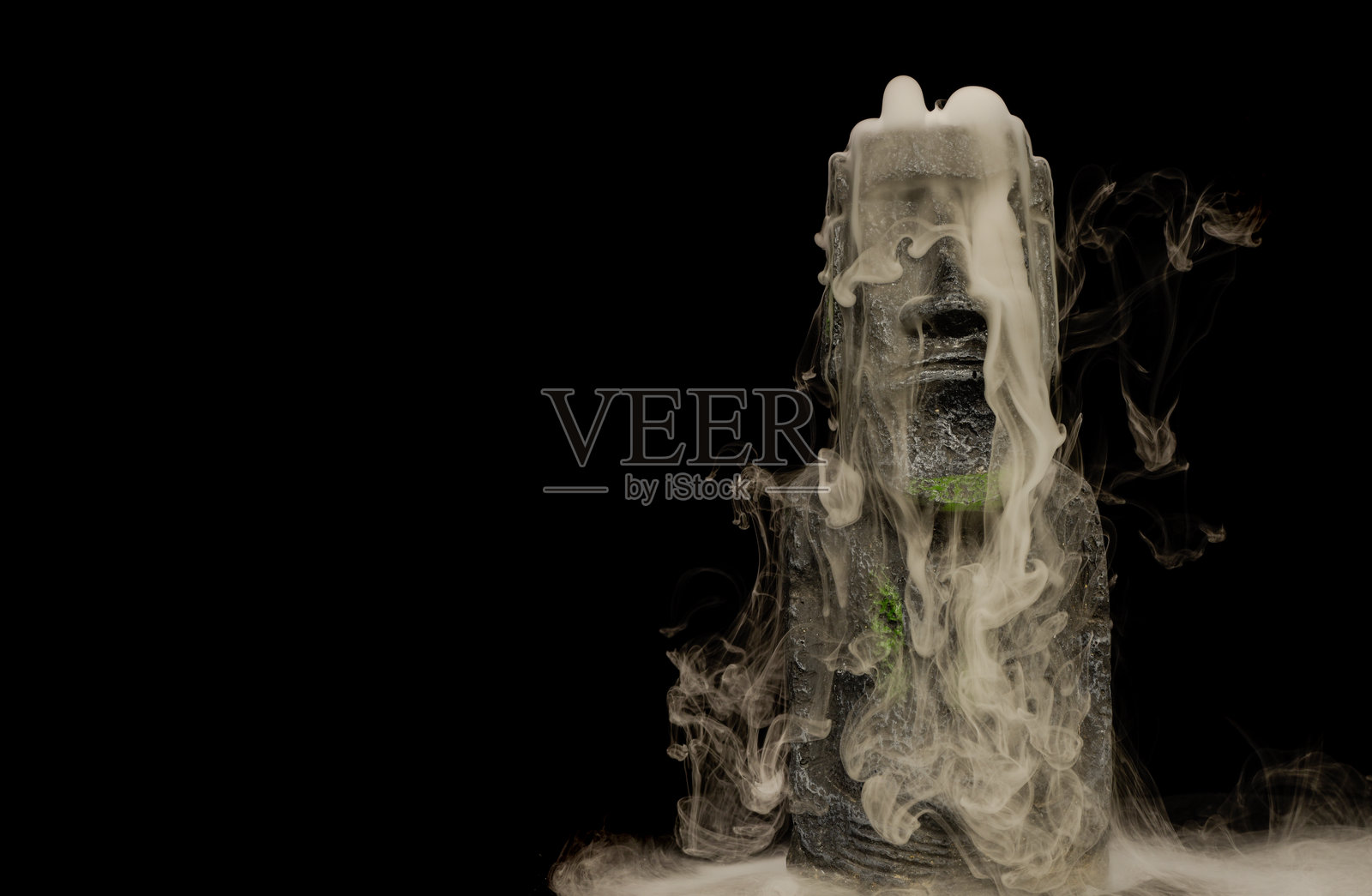 复活节岛石像静物，带有奇异的旋转烟雾和薄雾，由摄影师用硅胶模具和花园石块手工制作。照片摄影图片