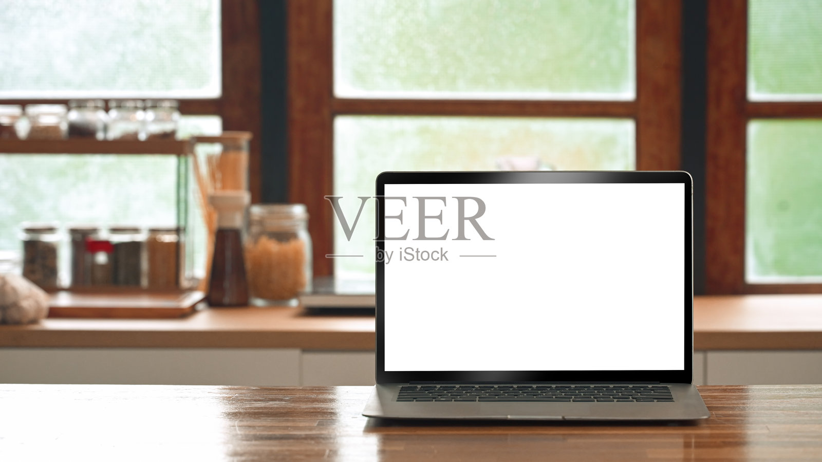 舒适厨房背景下，笔记本电脑放在木桌上，屏幕空白照片摄影图片