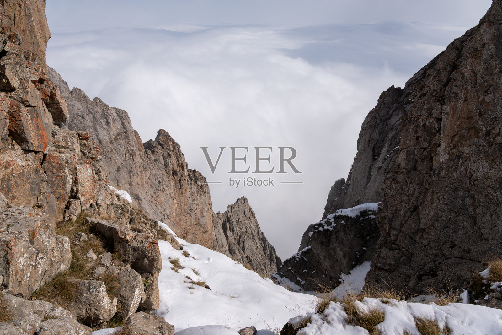 白雪覆盖的阿尔卑斯山脉笼罩在雾气和云层中照片摄影图片