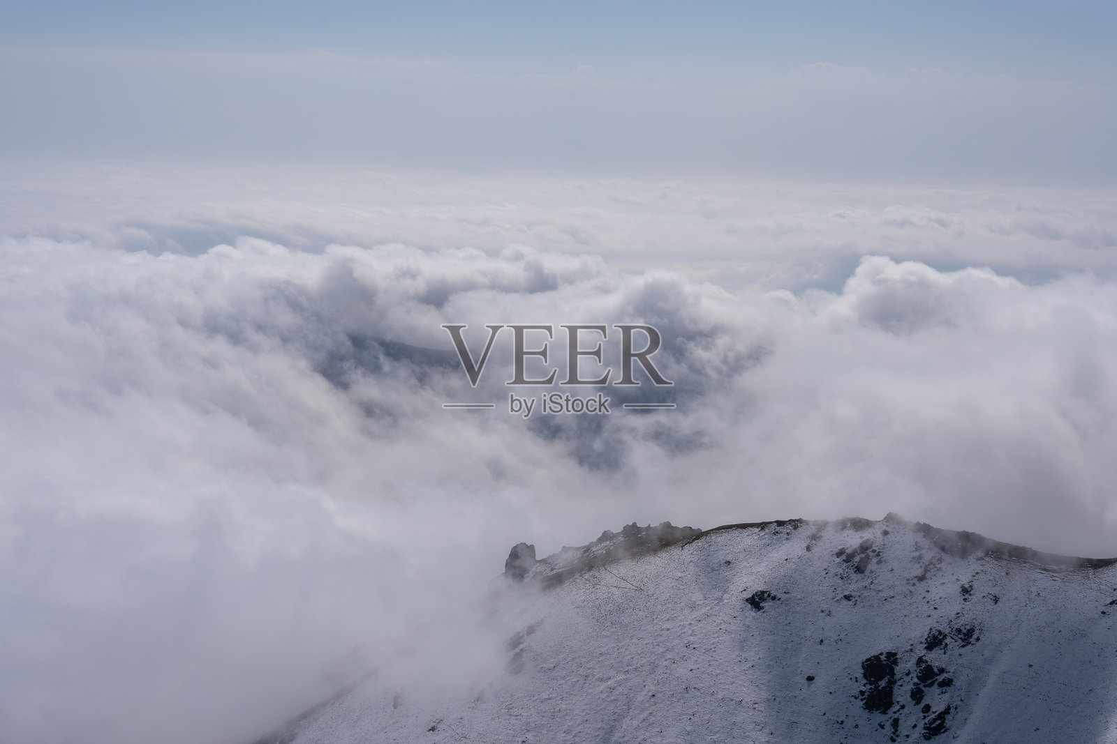 白雪皑皑的阿尔卑斯山脉笼罩在雾气和云层之中照片摄影图片