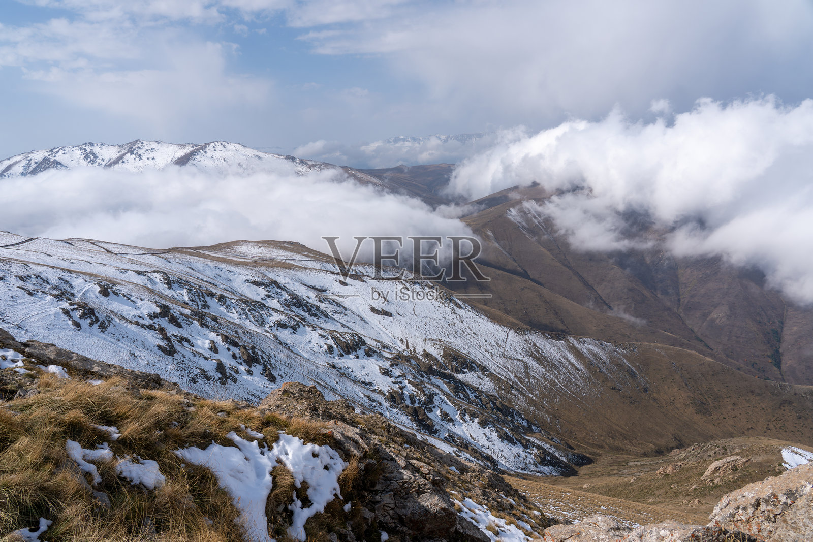 白雪皑皑的阿尔卑斯山脉笼罩在雾气和云层中照片摄影图片