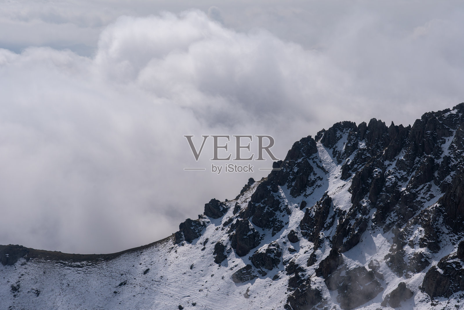 大雾和云层笼罩着雪山连绵的阿尔卑斯山脉照片摄影图片