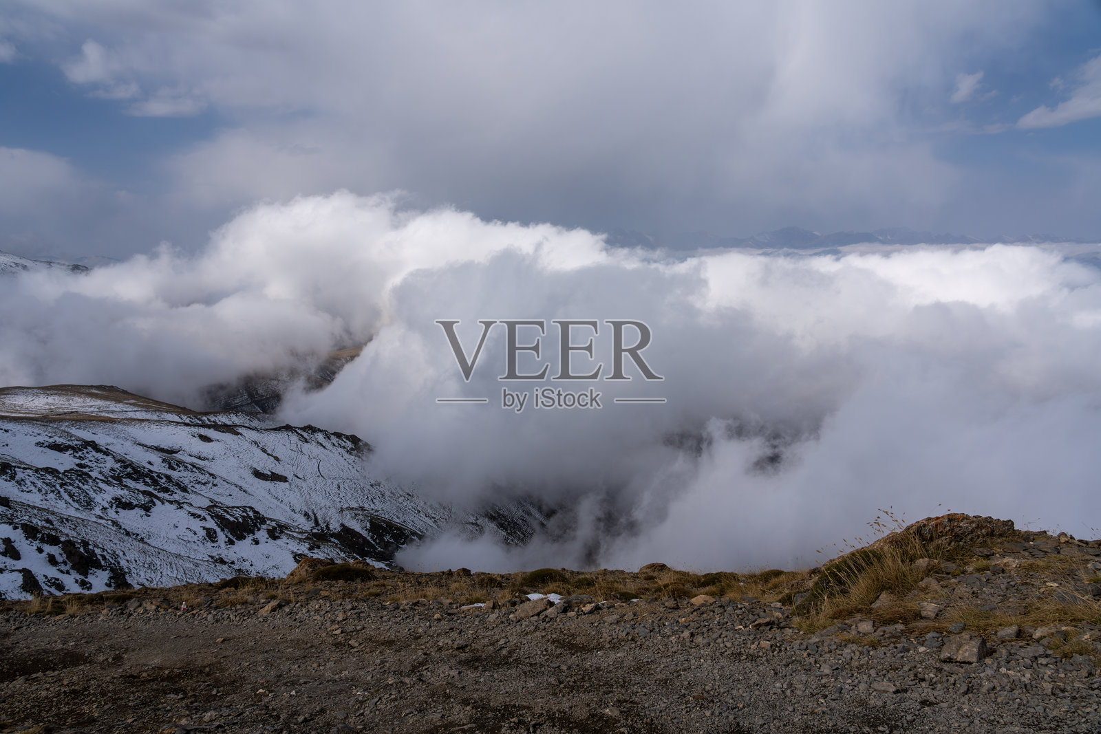 大雾弥漫、云遮雾绕的雪山山脉照片摄影图片