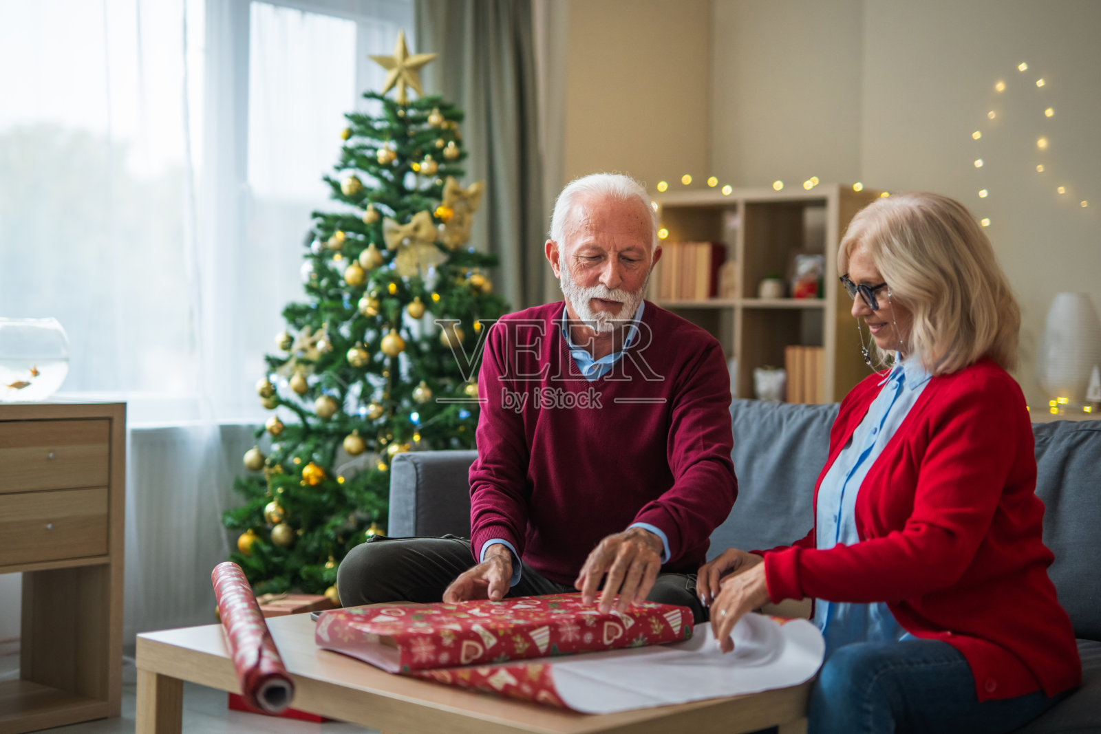 一对老年夫妇在客厅里一起包装圣诞礼物照片摄影图片