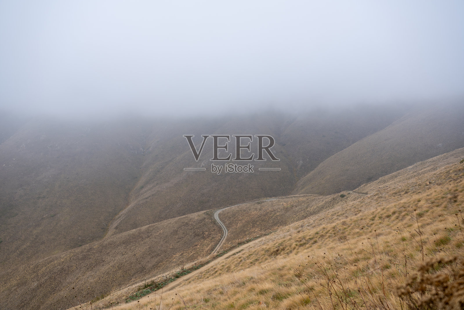 蜿蜒的山路消失在浓雾和薄雾中照片摄影图片