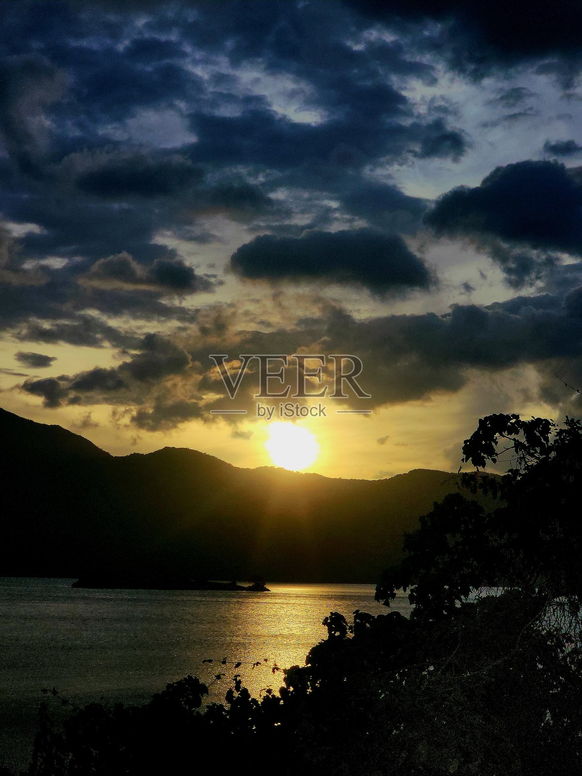 金色的光芒从黑暗的山峦剪影中升起，阿里亚尔水坝平静的水面倒映着新一天的温暖——宁静的日出以最纯粹的形式描绘了大自然的壮丽美景。照片摄影图片