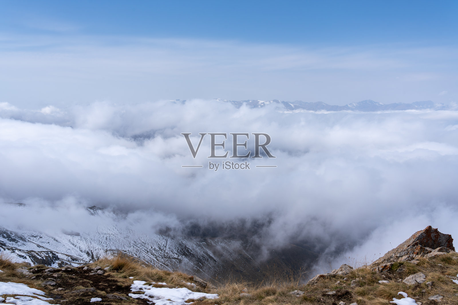 白雪覆盖的阿尔卑斯山脉笼罩在雾气和云层中照片摄影图片