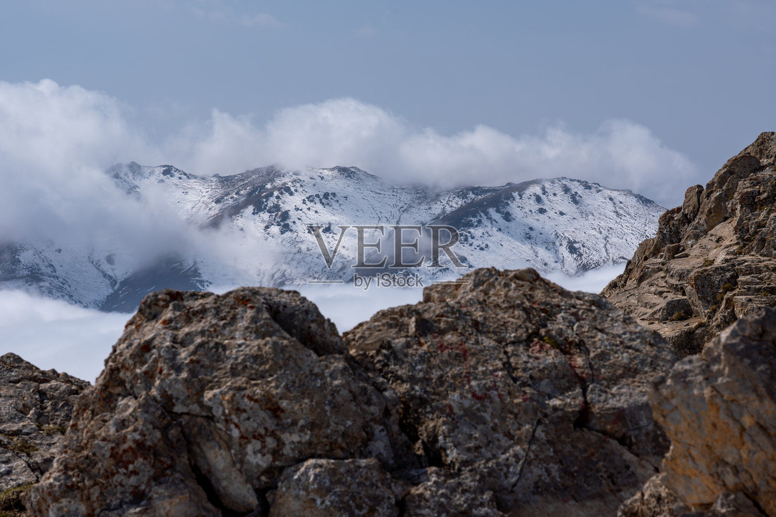 大雪覆盖的阿尔卑斯山脉笼罩在雾气和云层中照片摄影图片