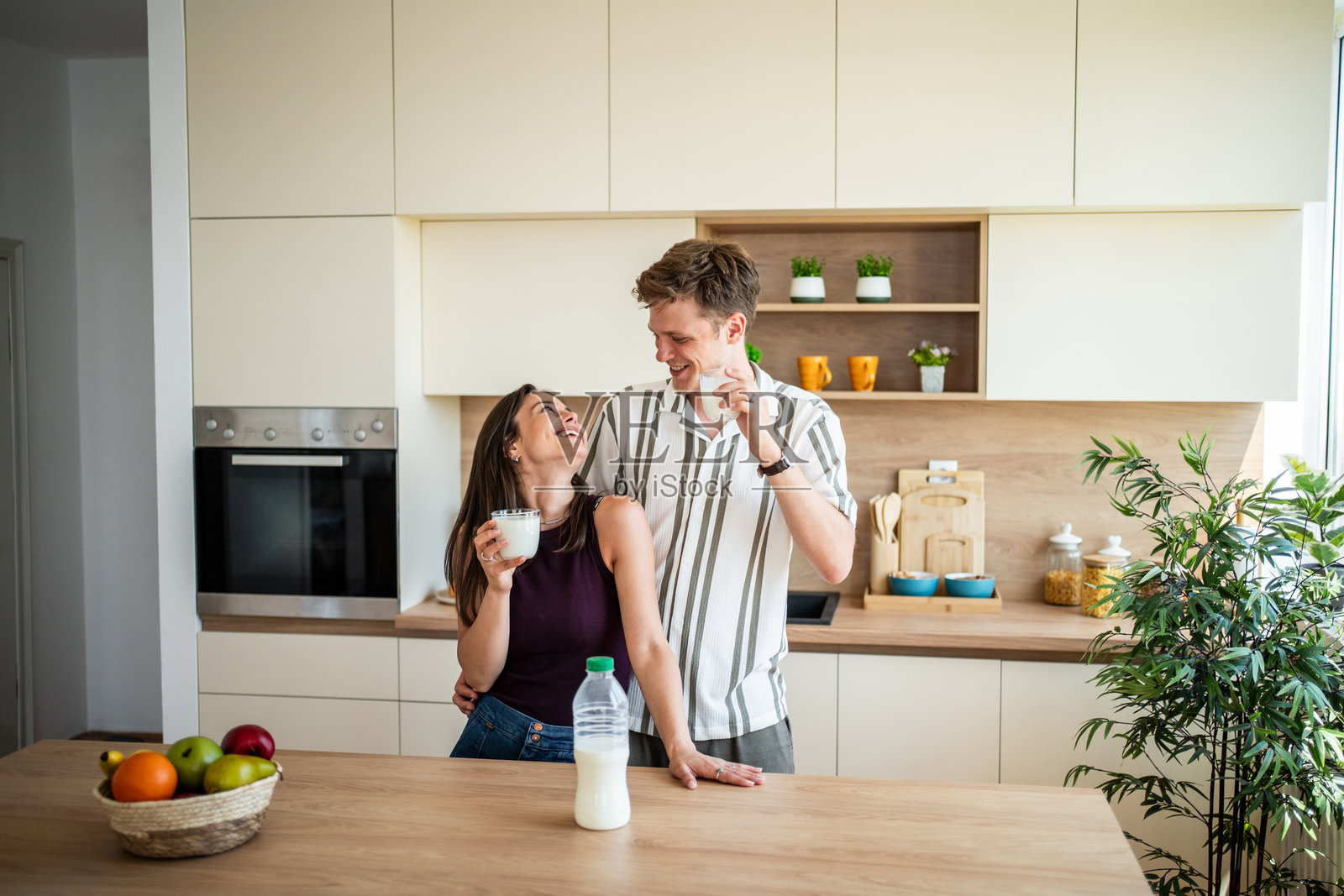 快乐情侣在现代厨房享用健康的早餐照片摄影图片