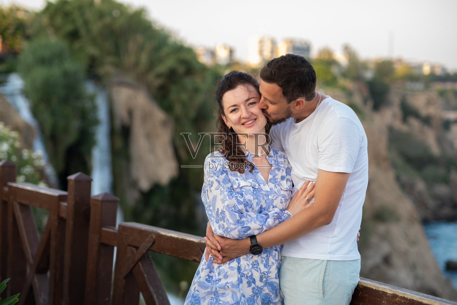 浪漫情侣在美丽的瀑布旁共度美好时光，记录下风景优美地点户外难忘的一天。照片摄影图片