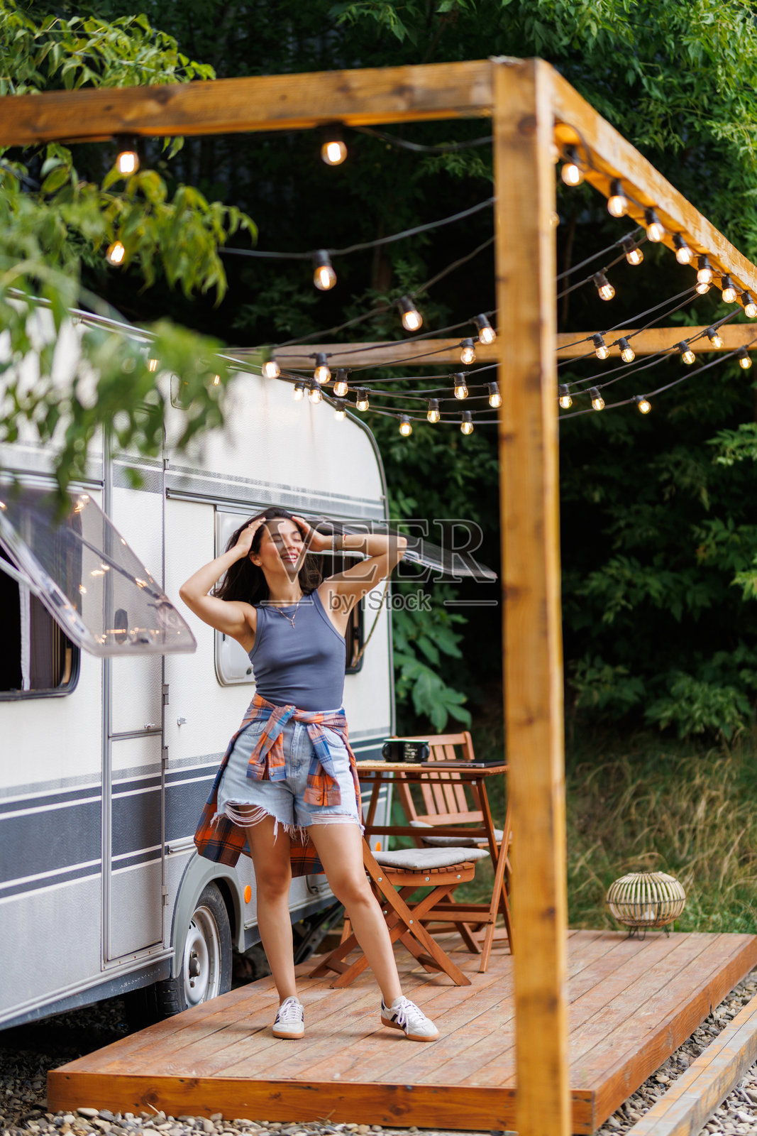 日落时分，一位漂亮的年轻女子在房车旅行中，在日落时分休息照片摄影图片