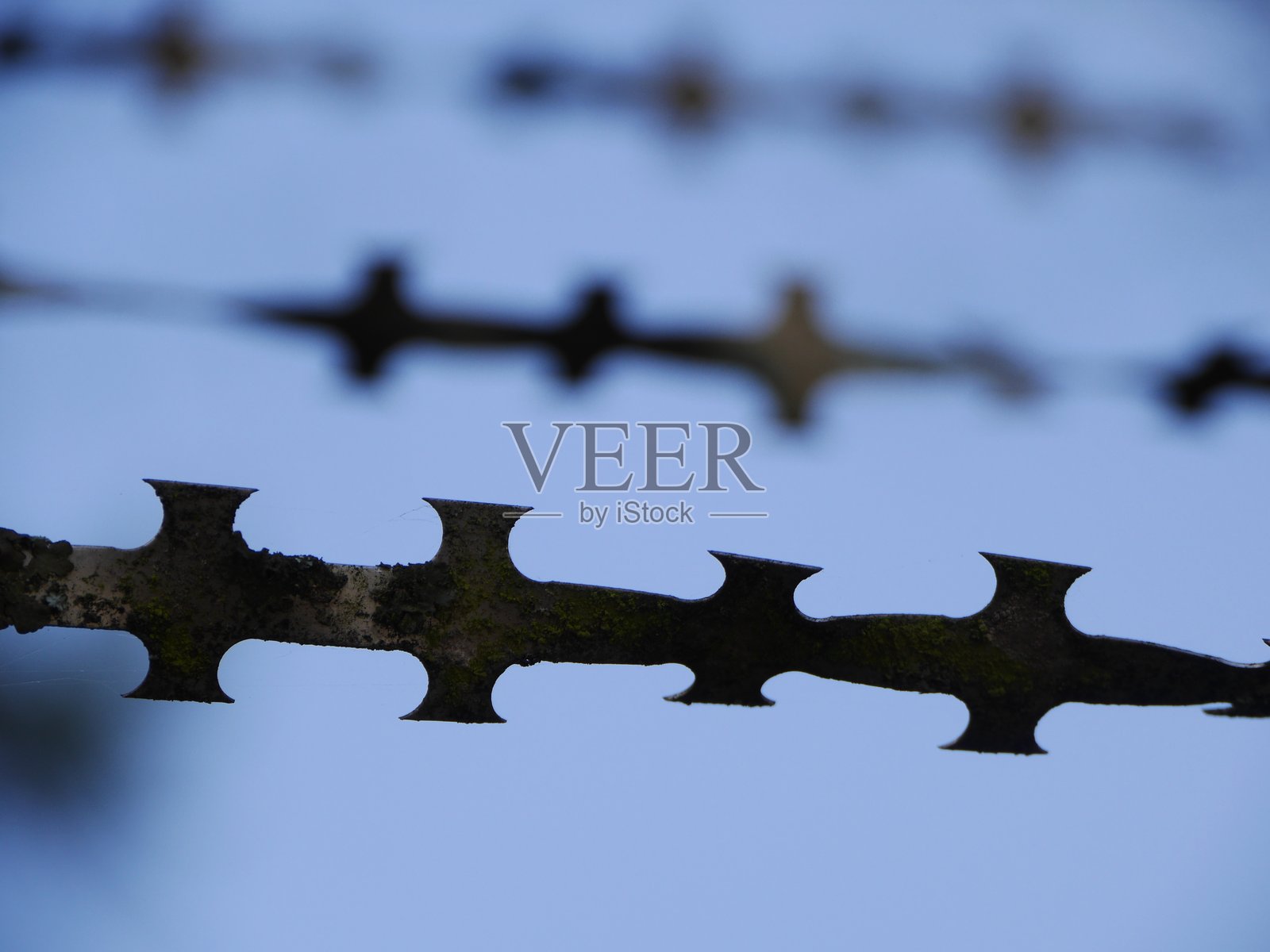 天空中布满尖刺的栅栏照片摄影图片