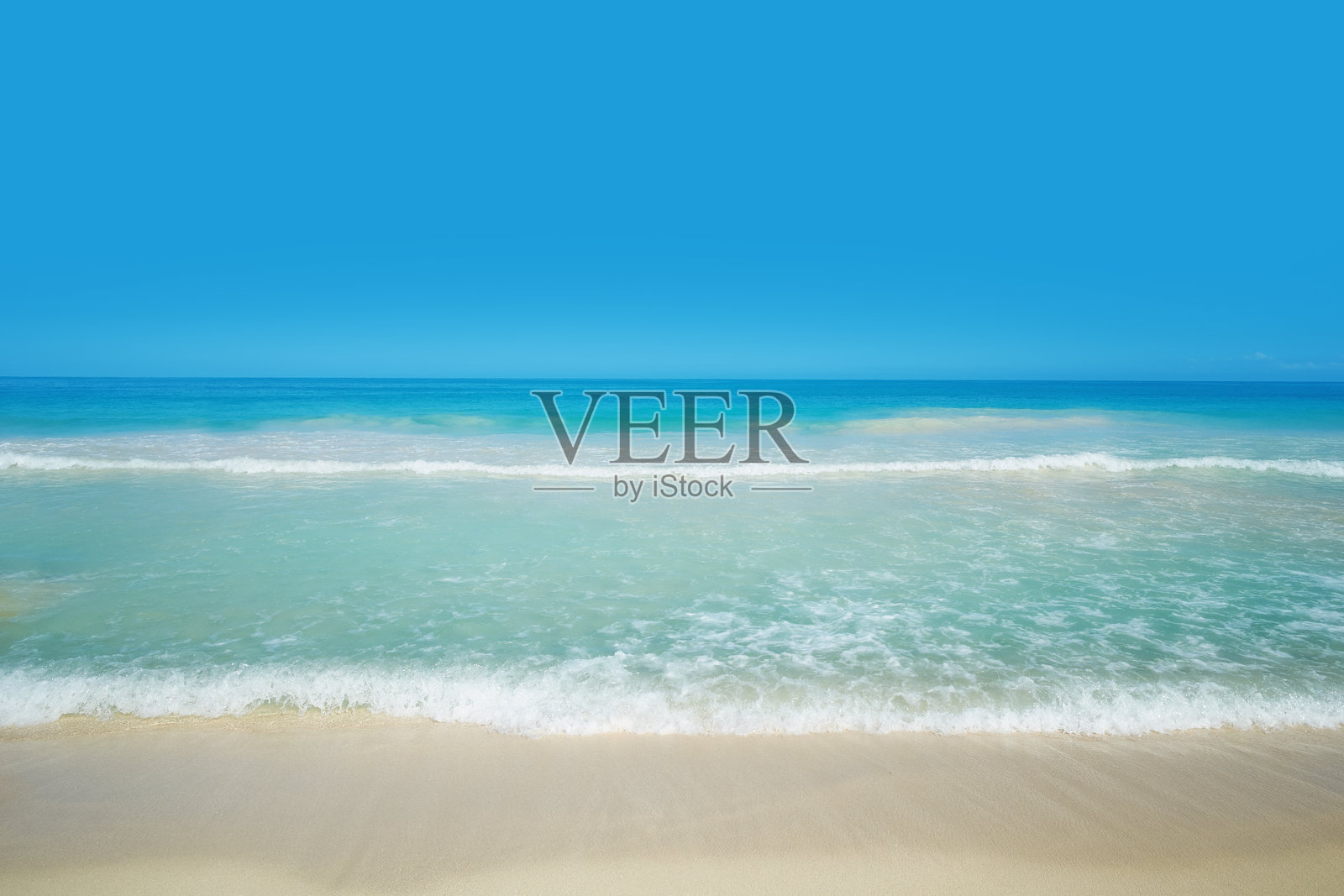 宁静的热带夏威夷海滩，碧绿的海浪拍打着沙滩，天空湛蓝。位于夏威夷瓦胡岛迎风海岸的拉尼凯海滩以其迷人的美景和宁静的氛围而闻名，拥有粉白色的沙滩和水晶般清澈的海水。照片摄影图片