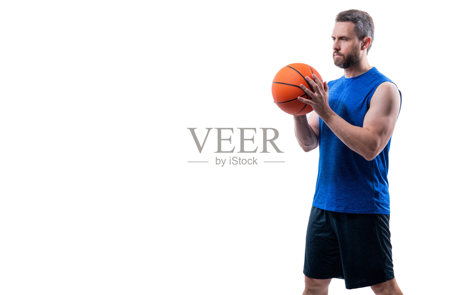 健壮的男人充满运动动力。运动与爱好。职业篮球运动员。篮球场上的男人与篮球。职业篮球运动员在白色背景下训练，留有复制空间。照片摄影图片