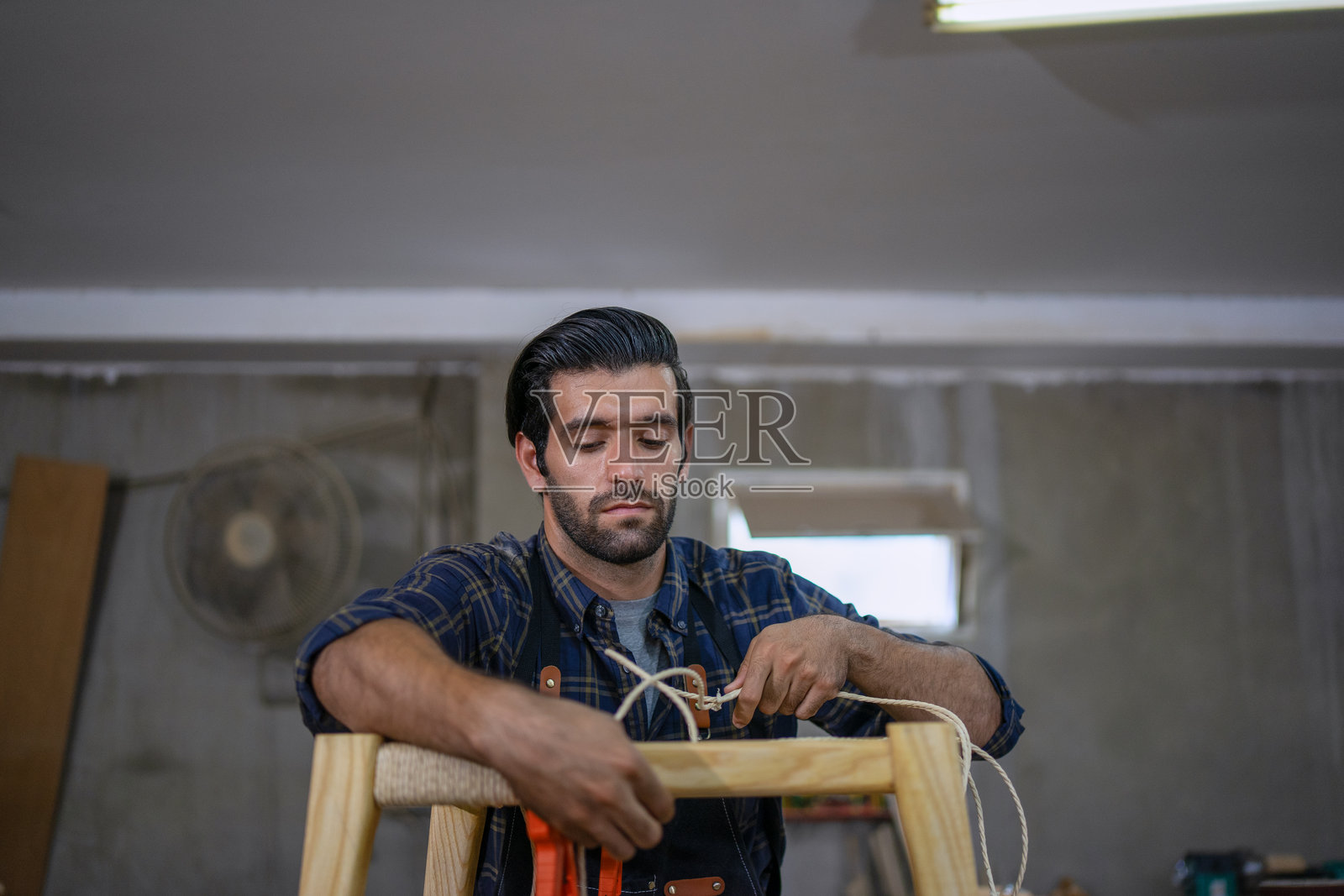 木匠在工作室里工作。照片摄影图片