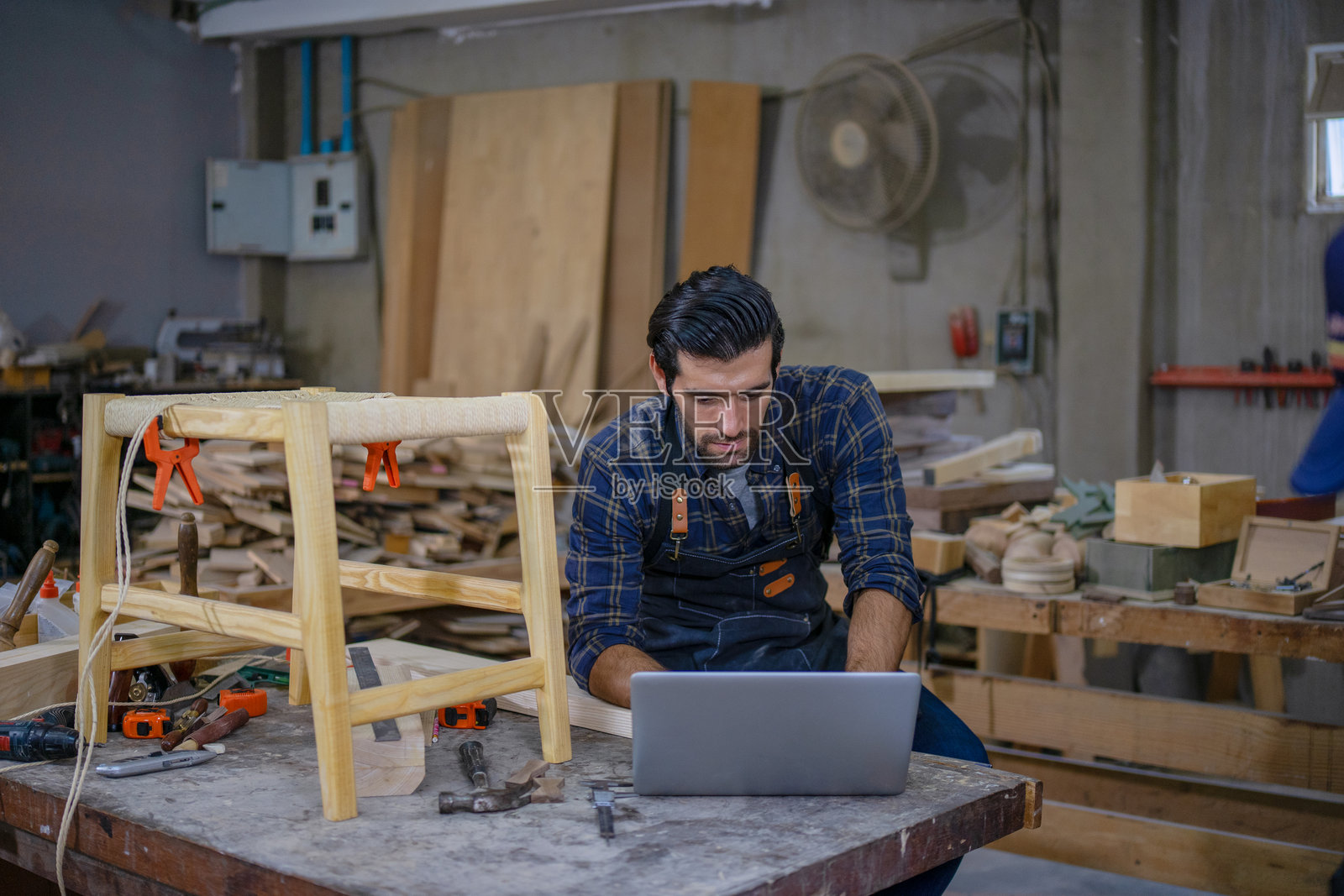 木匠在工作室工作。照片摄影图片