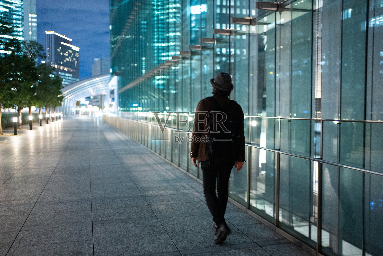 戴帽子的男人走在商业区照片摄影图片