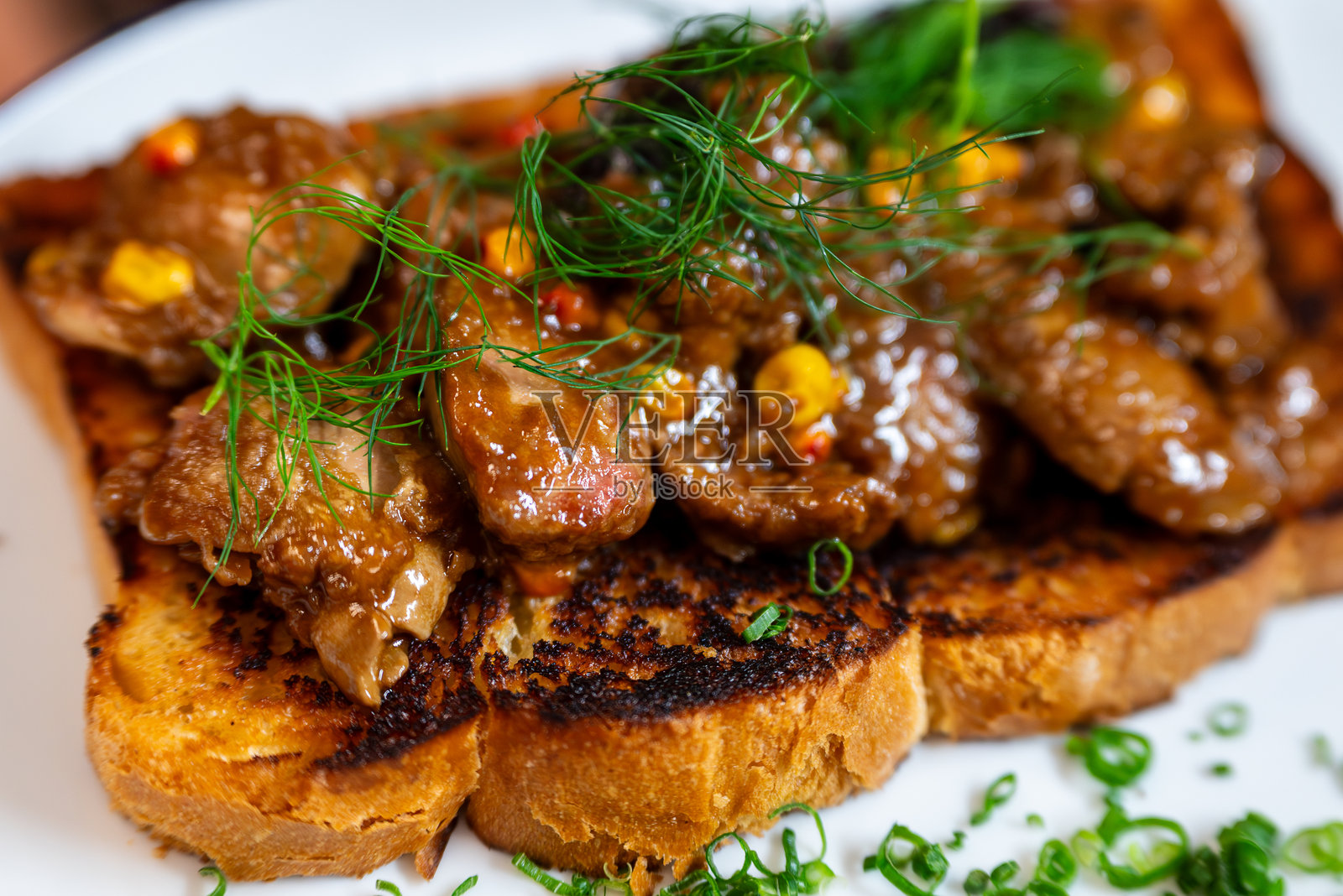 烤羊腰子配莳萝，放在一片烤面包上照片摄影图片