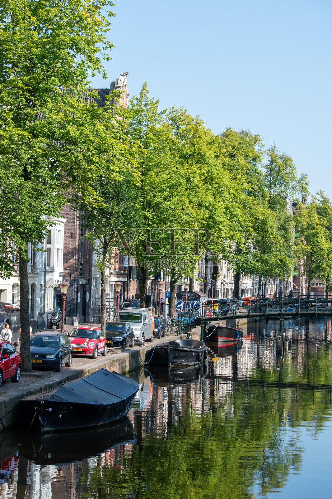 阿姆斯特丹林荫运河上的城市景观，有桥梁和水面倒影。照片摄影图片