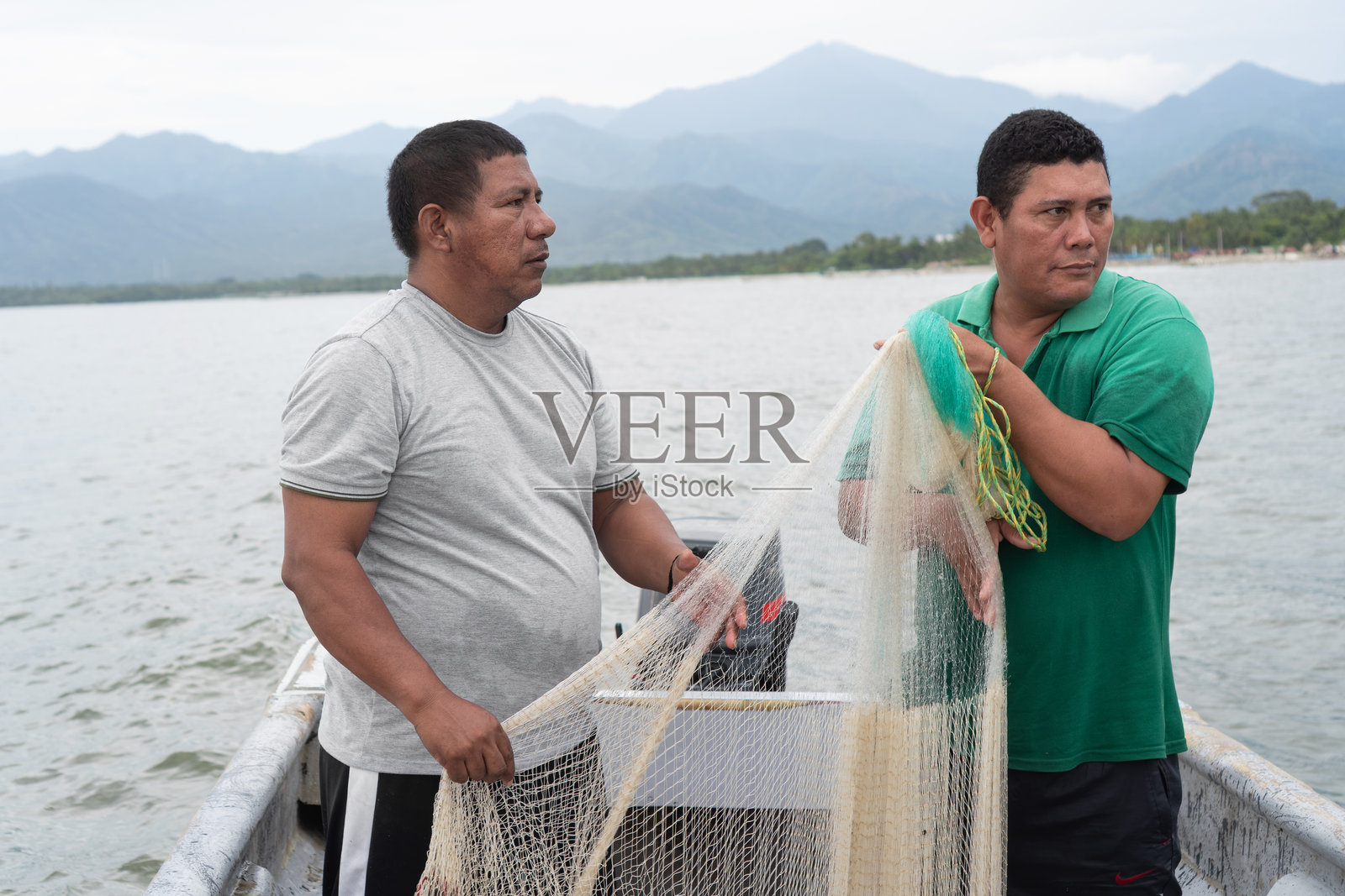 渔民在热带海域的船上准备渔网照片摄影图片