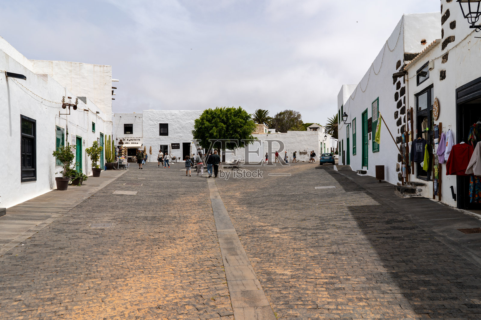 游客在阳光明媚的日子里漫步于兰萨罗特岛特吉塞的历史悠久的主广场。照片摄影图片