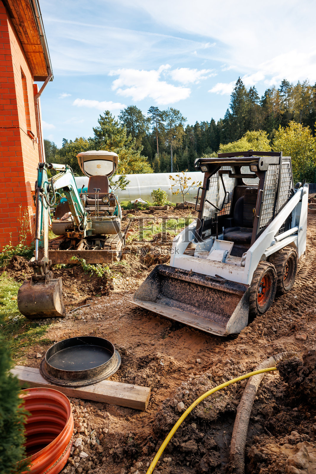 泥土上的装载机和小型挖掘机建筑工地照片摄影图片