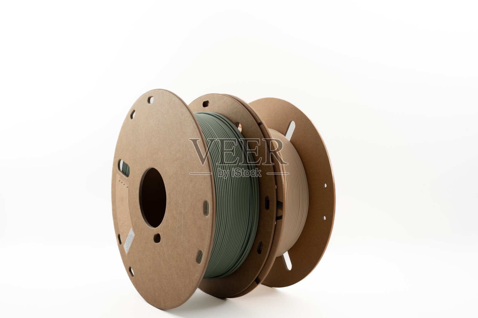 白色背景上水平排列的哑光绿、米色PLA 3D打印线材卷照片摄影图片