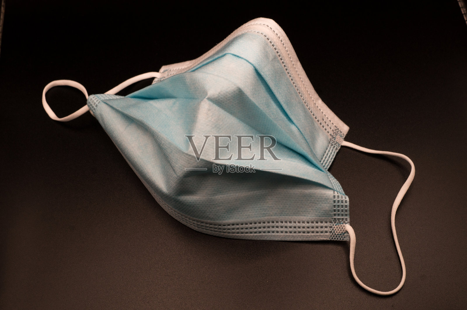 黑色背景上的用过的外科口罩照片摄影图片