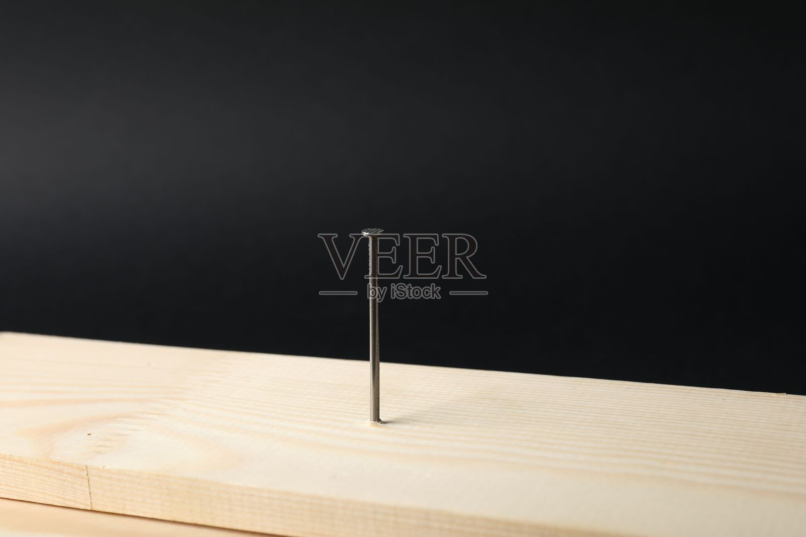 木板上的金属钉子，黑色背景，特写照片摄影图片