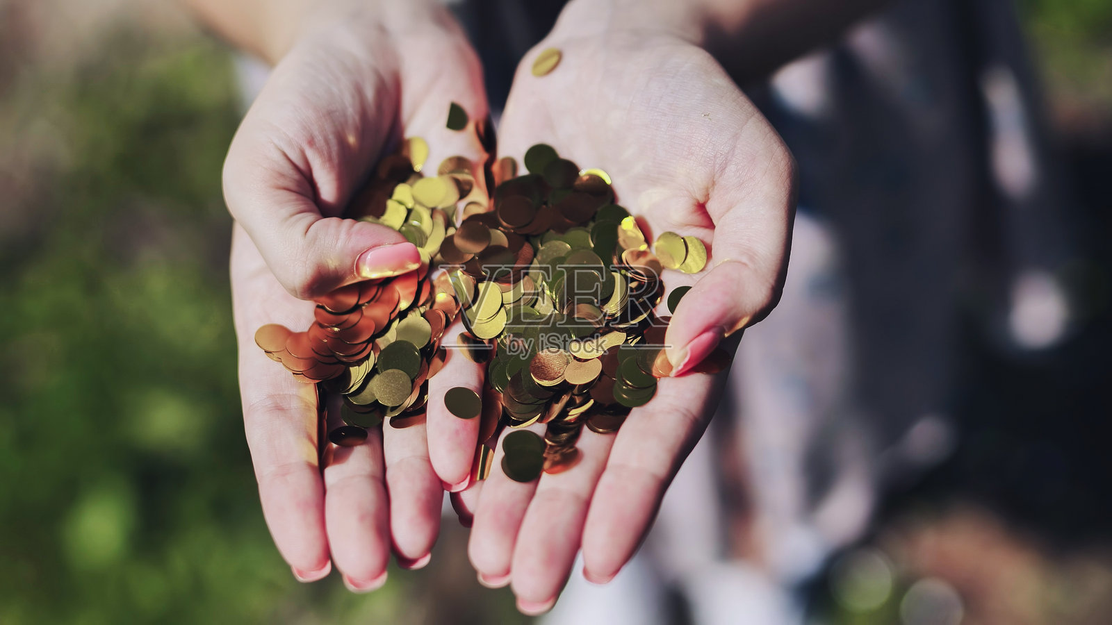 女人撒着金色纸屑，用喜悦的手势庆祝人生中的重要里程碑和节日般的个人成就。照片摄影图片