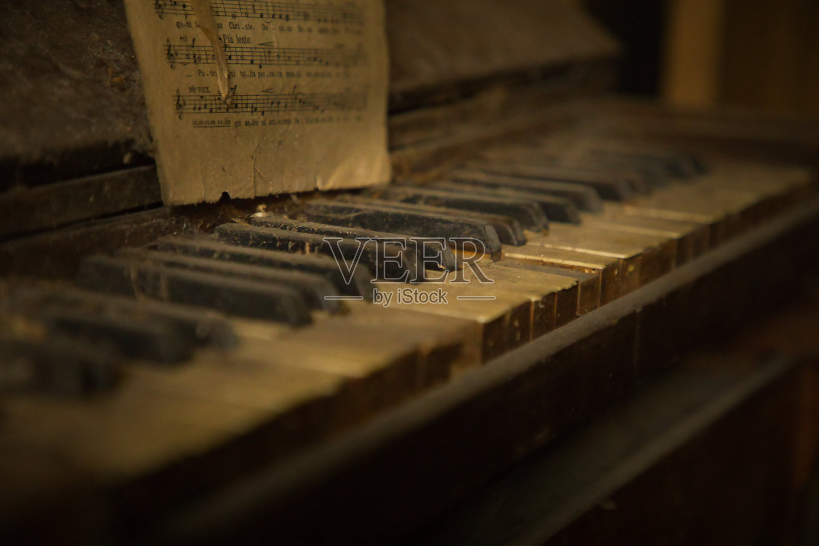 时光流逝，遗忘在时间里。被遗弃的见证与证词。旧钢琴和琴键。布满灰尘、被遗弃、关闭且被遗忘。照片摄影图片